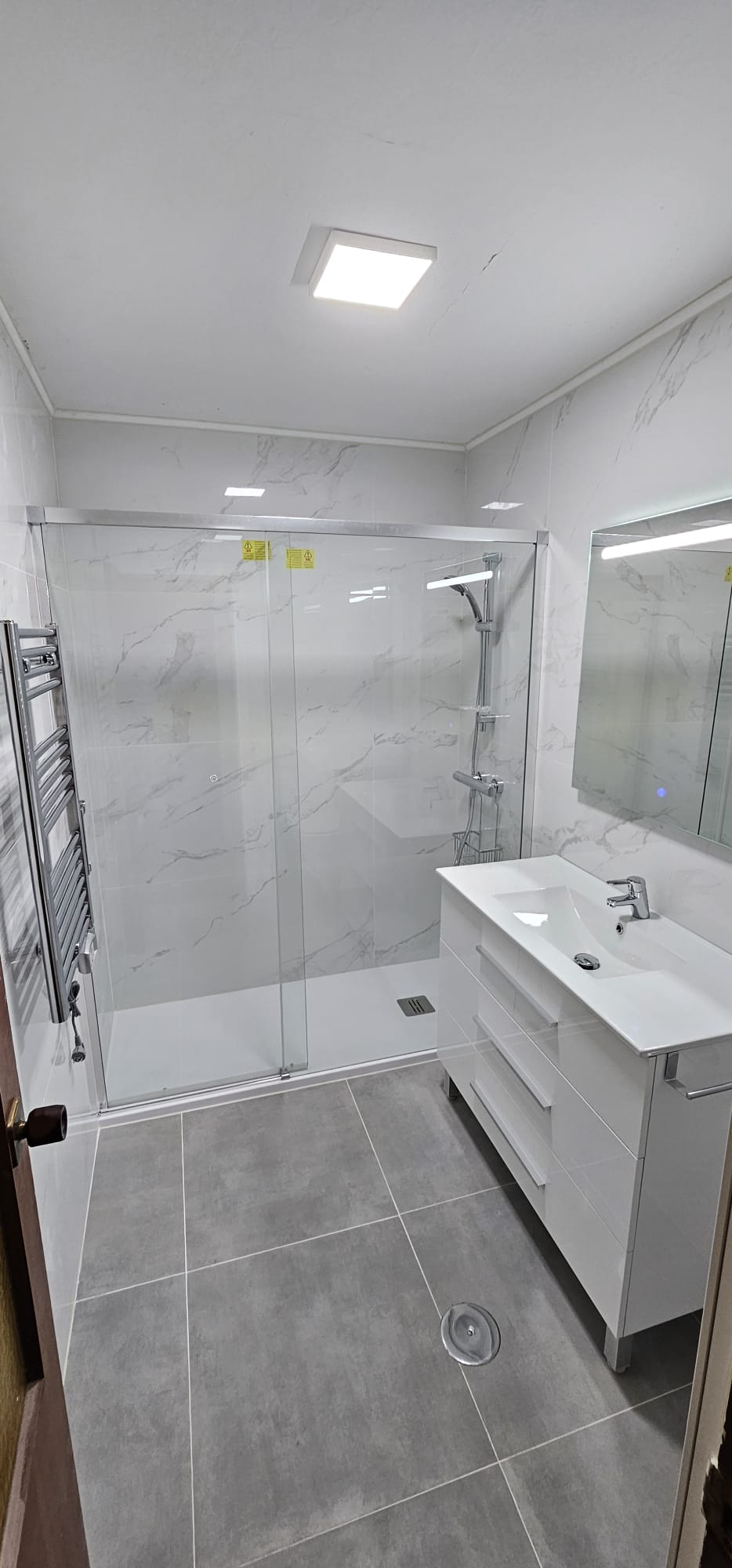 Reforma de baño en Coruña con revestimiento tipo mármol blanco